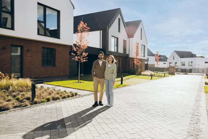 Pareja delante de su vivienda en una calle residencial